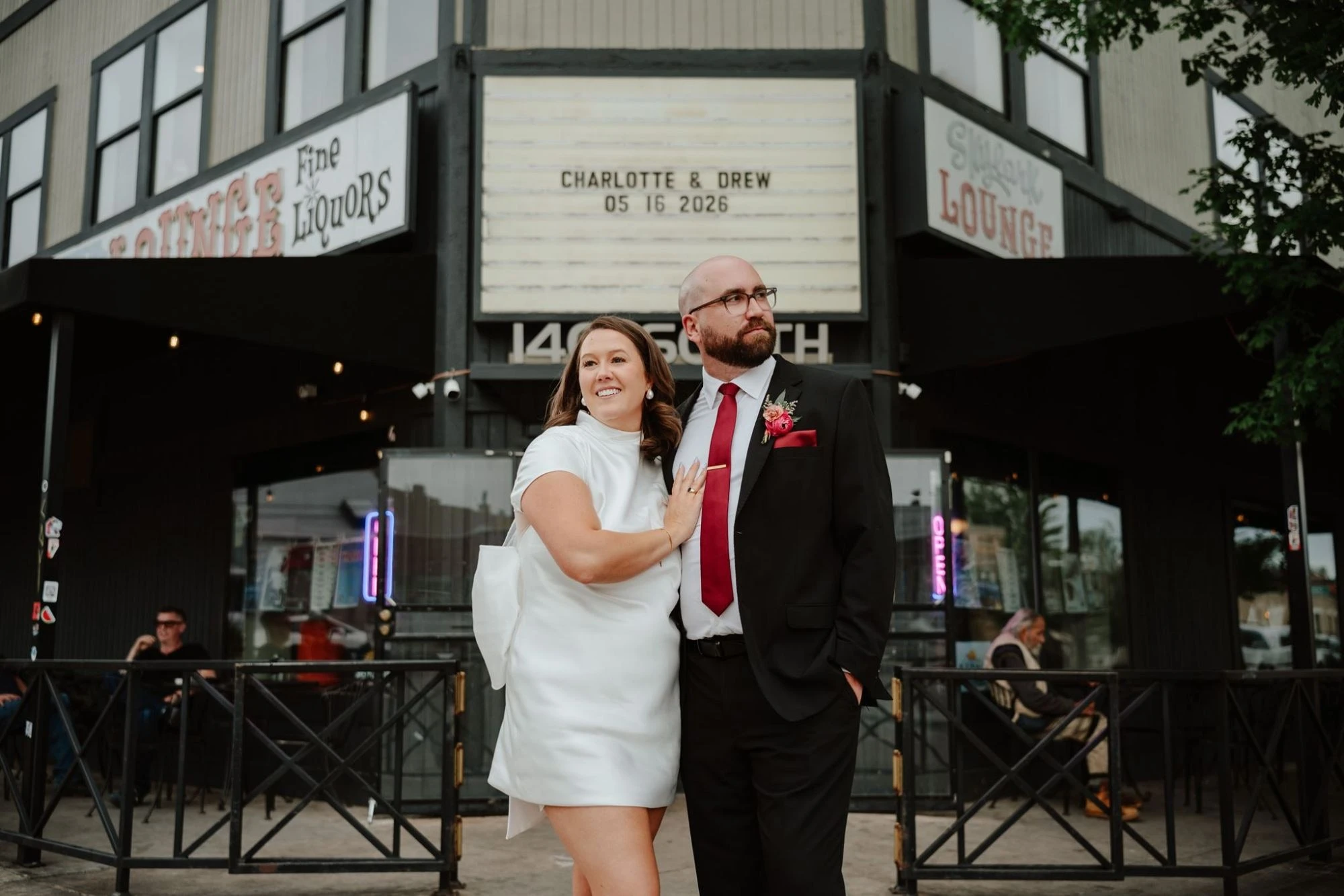 Drew and Charlotte outside the Skylark Lounge, its marquee reading “Charlotte & Drew, 05 16 2026.”